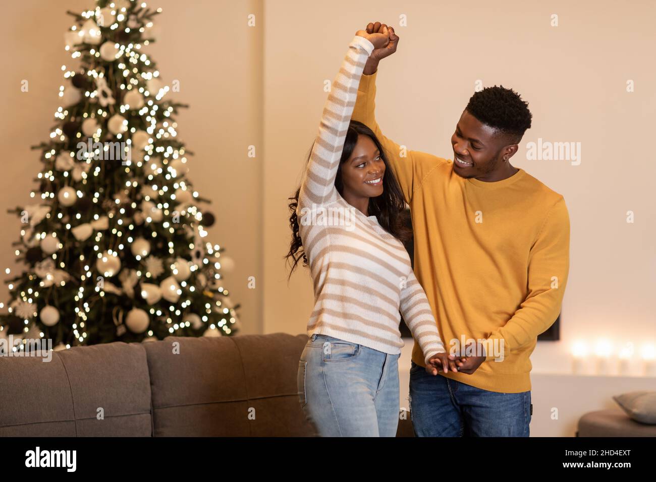 Black Couple Dancing Near Christmas Tree Celebrating New Year Indoor Stock Photo
