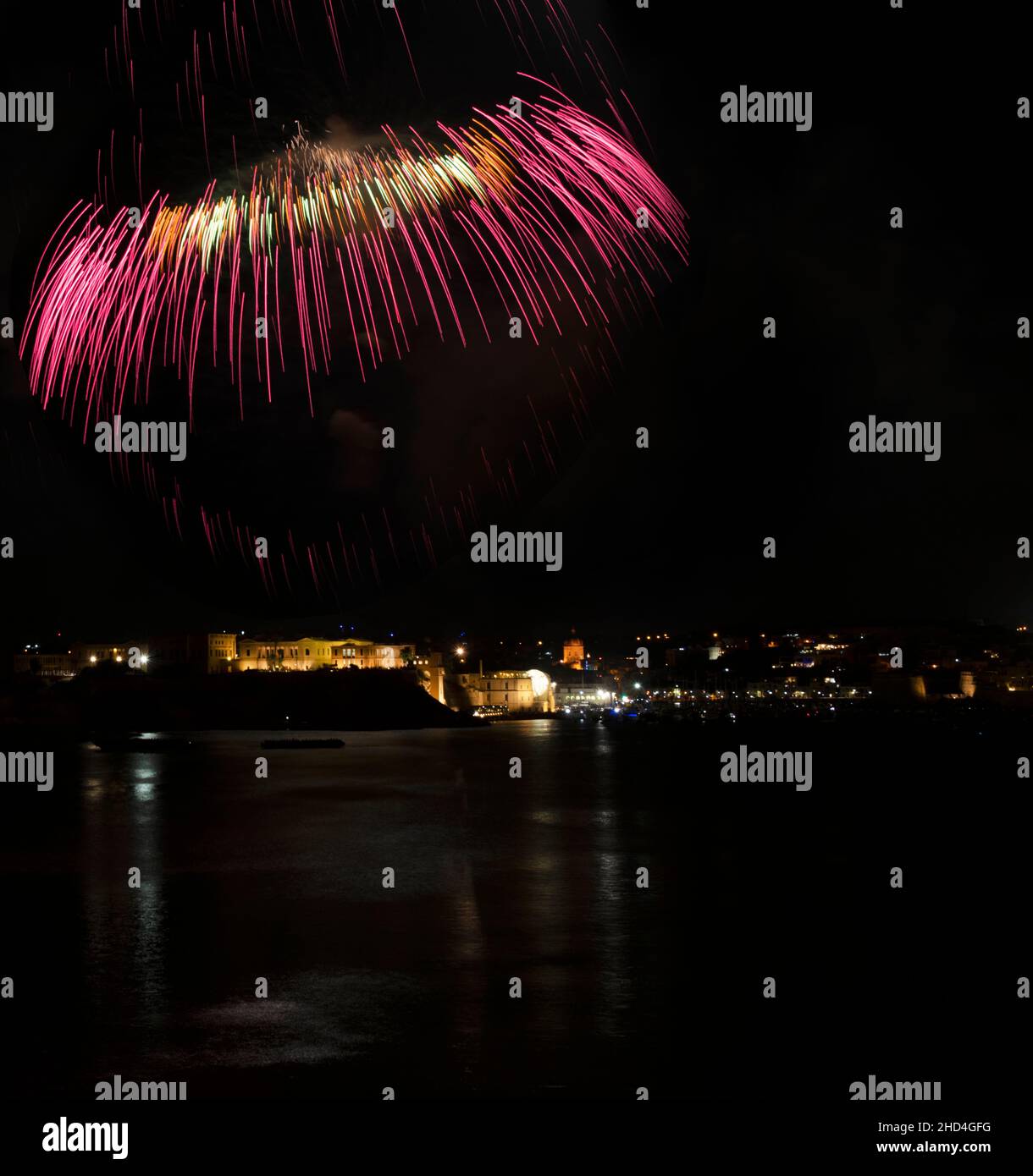 Colorful amazing fireworks in Kalkara, Malta with city view and reflection in the sea, city silhouette, Malta fireworks festival,Independence day,expl Stock Photo