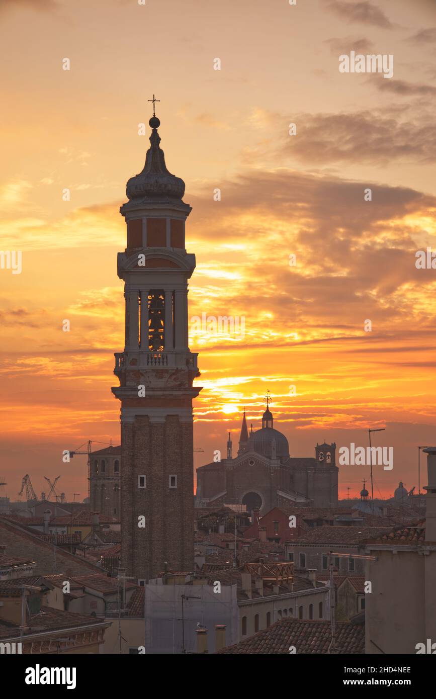 Venice skyline viewed across the city's rooftops at sunrise with bell tower of Church of the Holy Apostles of Christ in foreground Stock Photo
