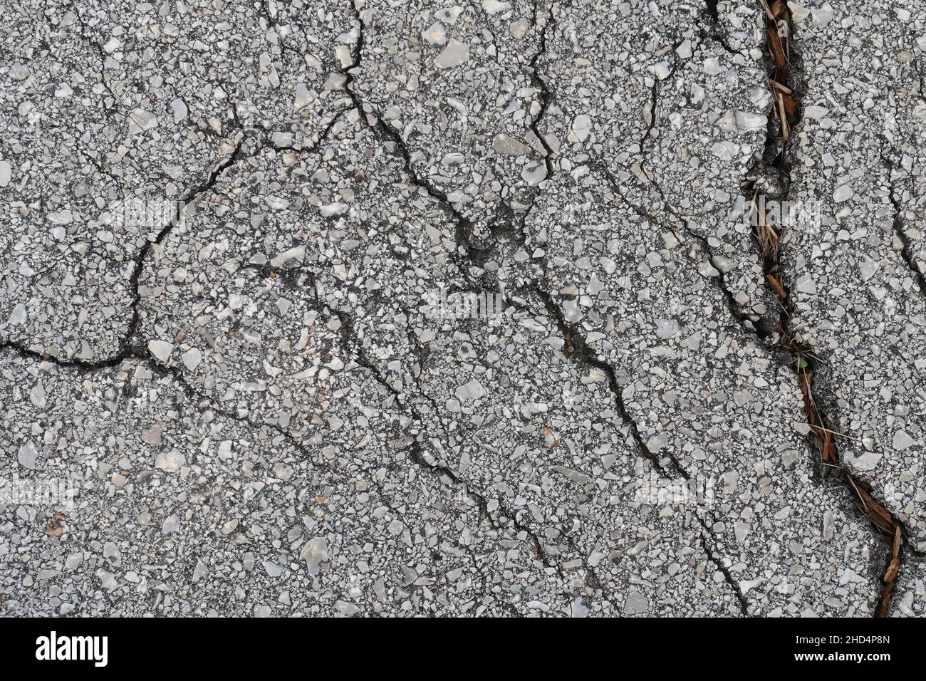 Cracked road asphalt detail. Textured background. Stock Photo