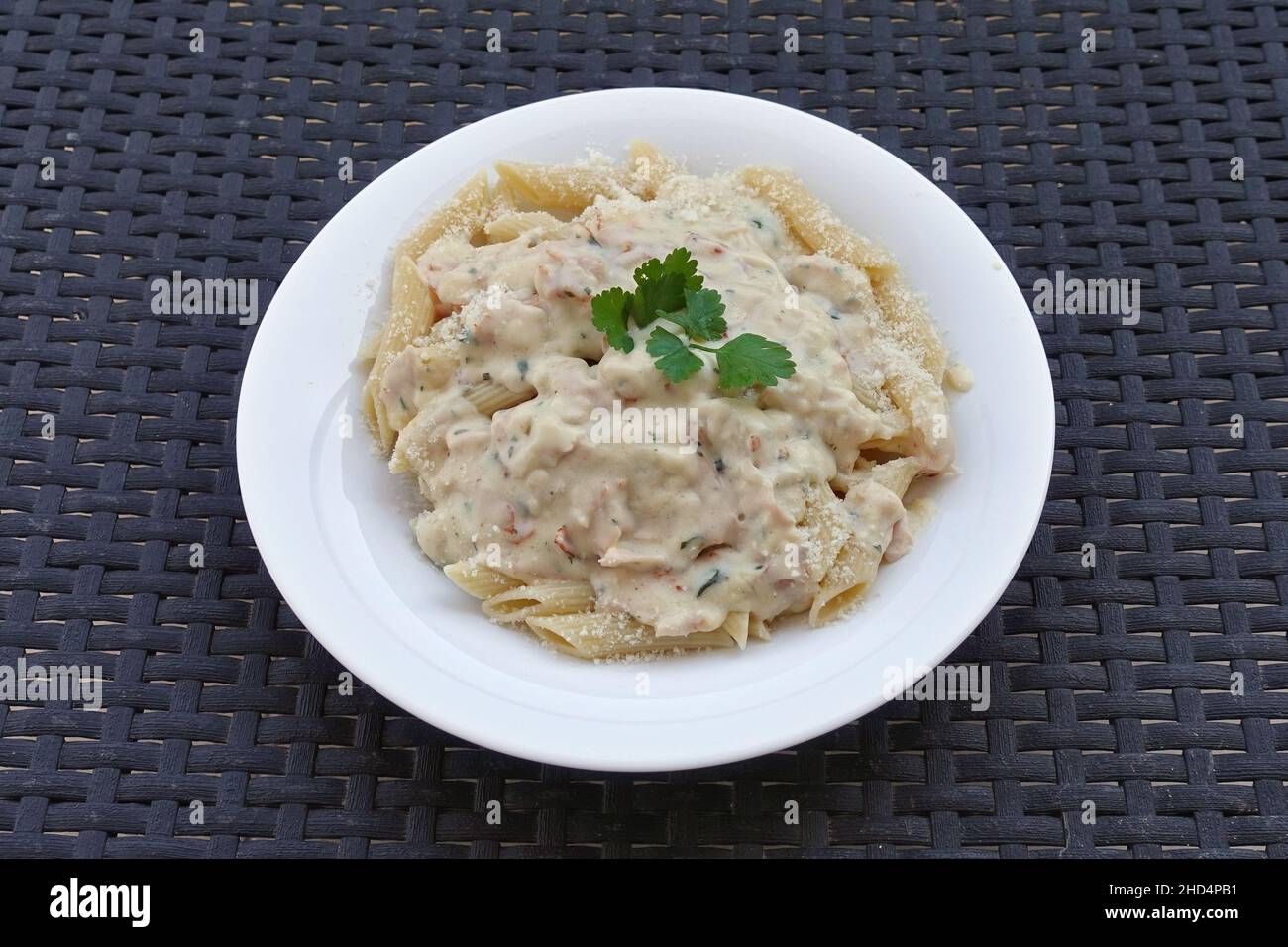 Penne pasta with carbonara sauce and parmesan cheese. Italian food. Stock Photo