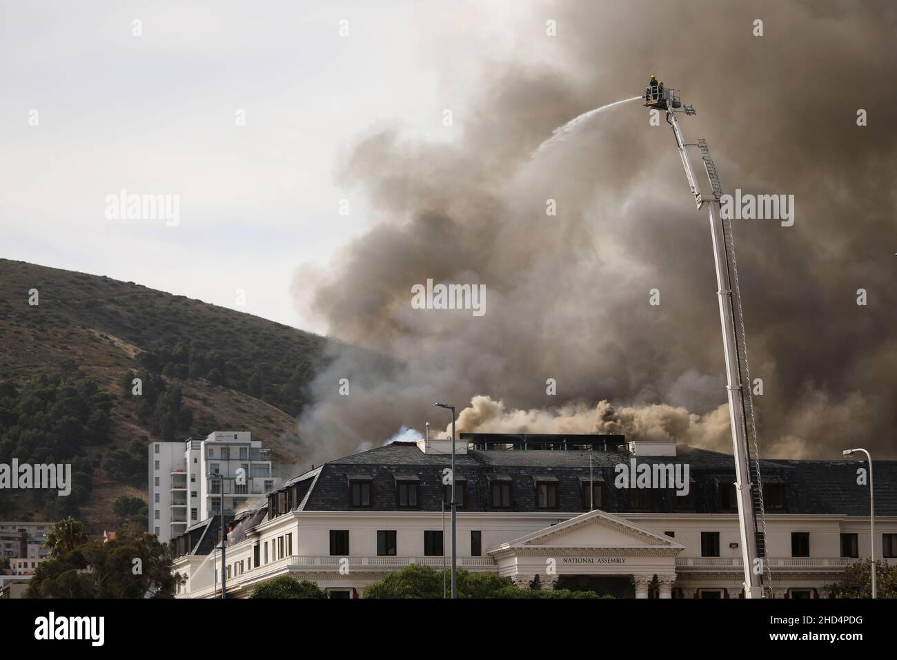 Firemen work at the parliament where a fire broke out in Cape Town, South Africa, January 3, 2022. REUTERS/Mike Hutchings Stock Photo