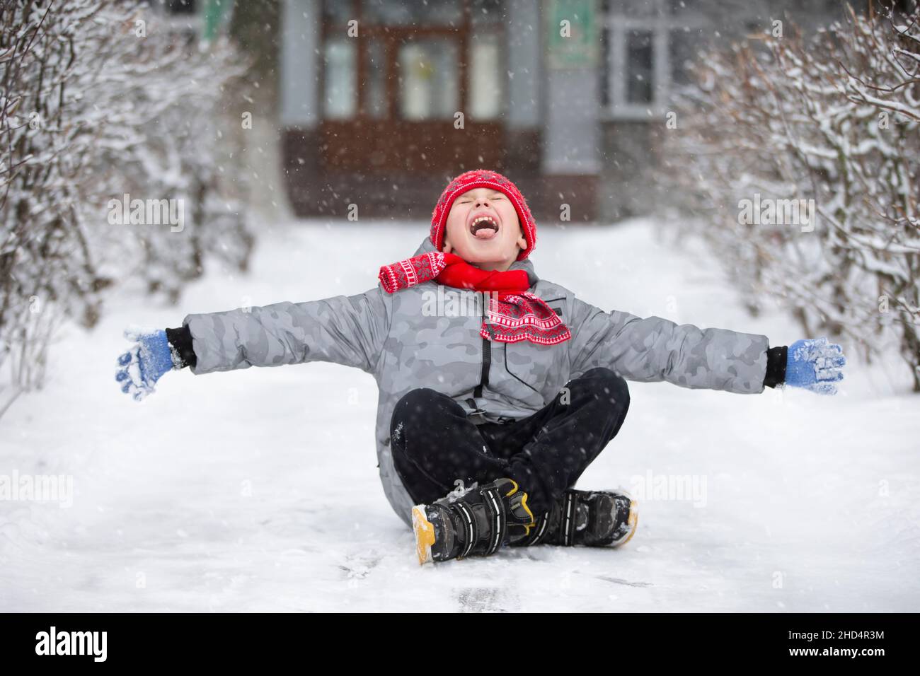 Happy boy catches snowflakes with his mouth. The child rejoices