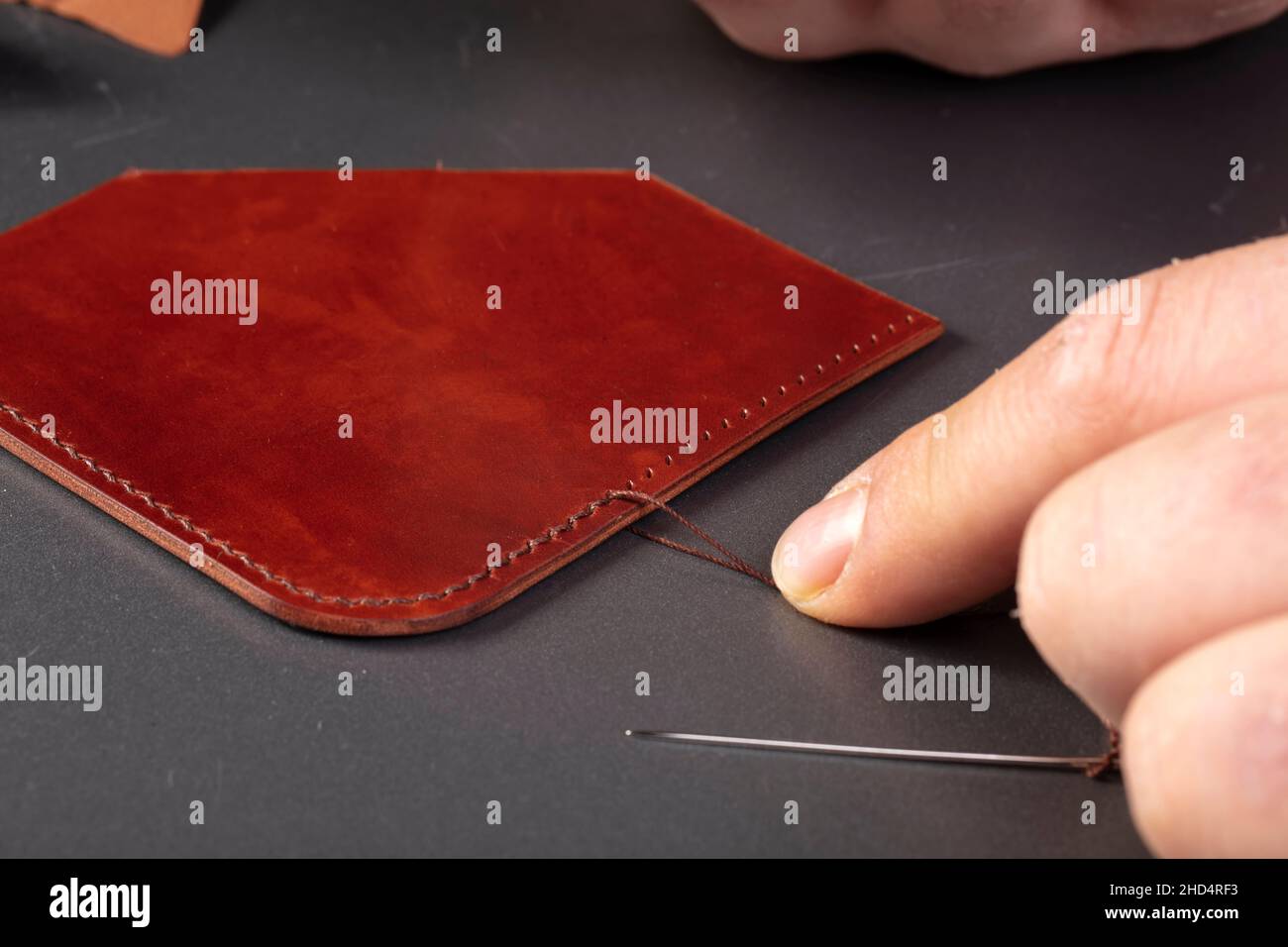 The process of making leather goods. The hands of the master work with