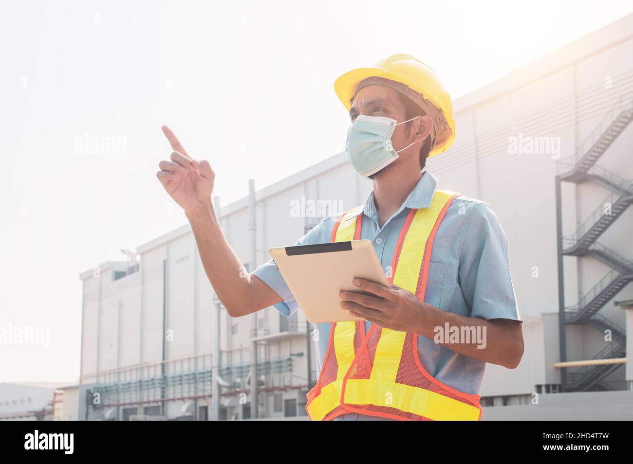 Engineer holding tablet standing outdoor factory background Stock Photo