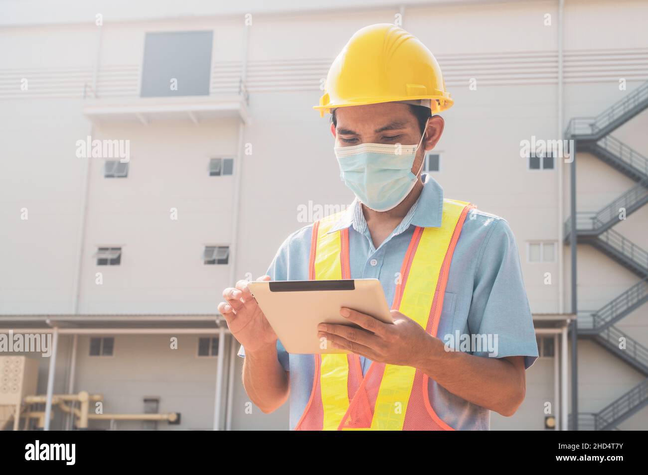 Engineer holding tablet standing outdoor factory background Stock Photo