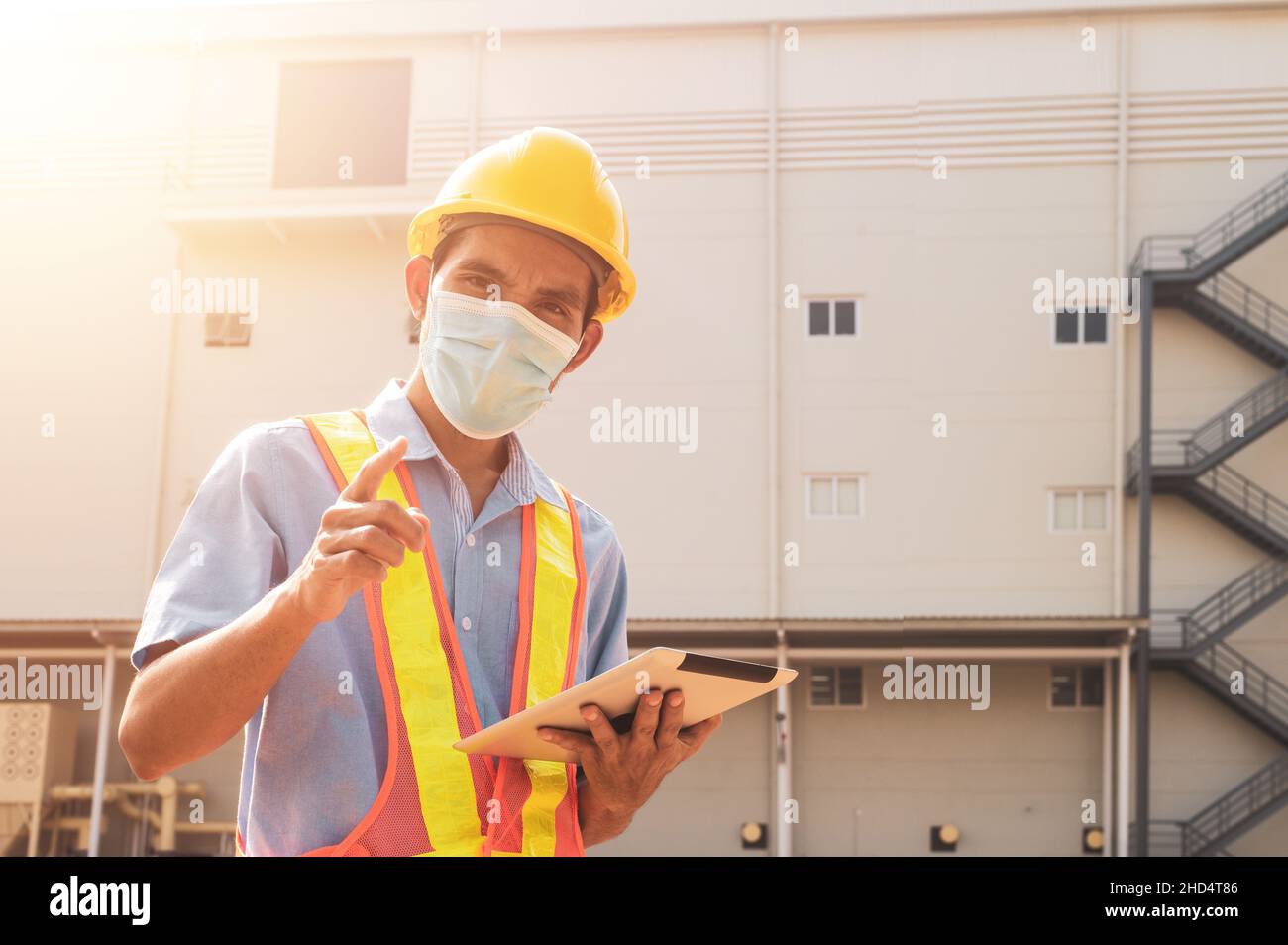 Engineer holding tablet standing outdoor factory background Stock Photo