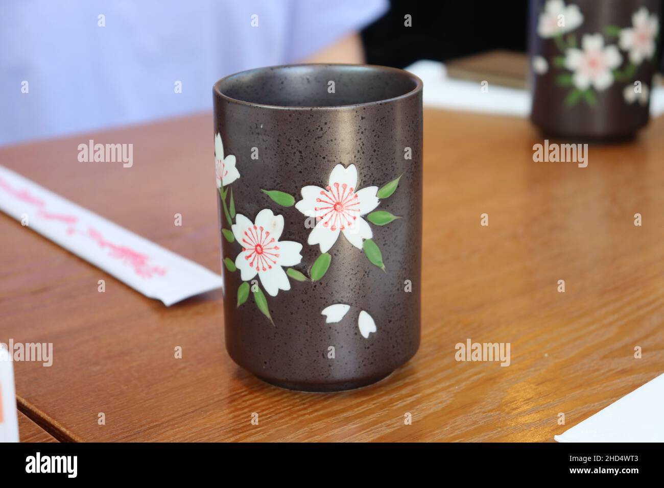 A simple stone cup with a cherry blossom design on it Stock Photo
