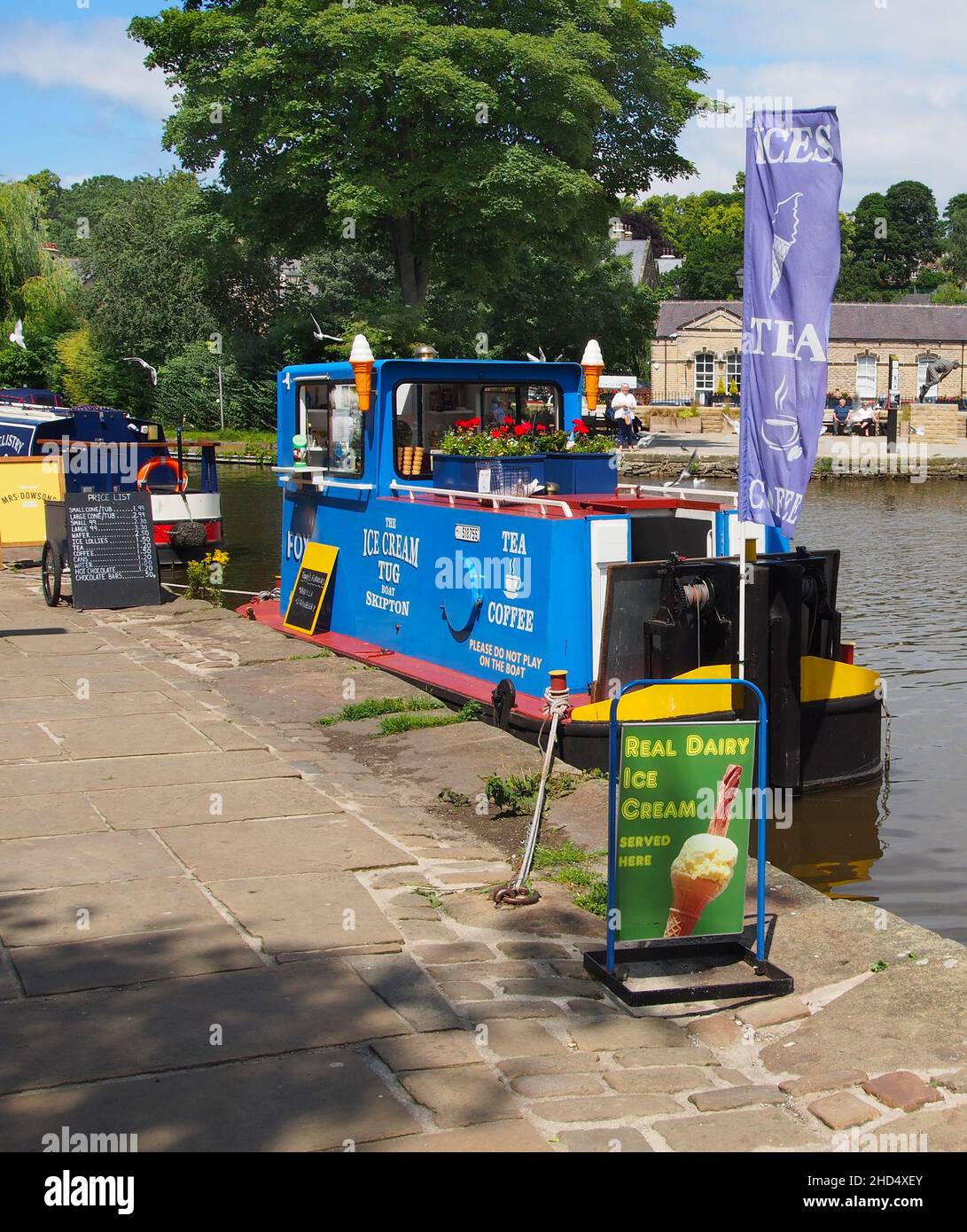 The ice cream boat moored in the sunshine at the canal basin on the Leeds and Liverpool canal in Skipton, North Yorkshire, England. Stock Photo