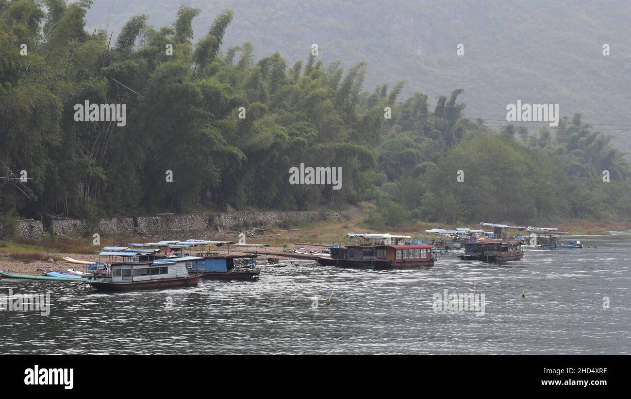 Boats on Li river in Yangshuo China. Trees in the background. Stock Photo