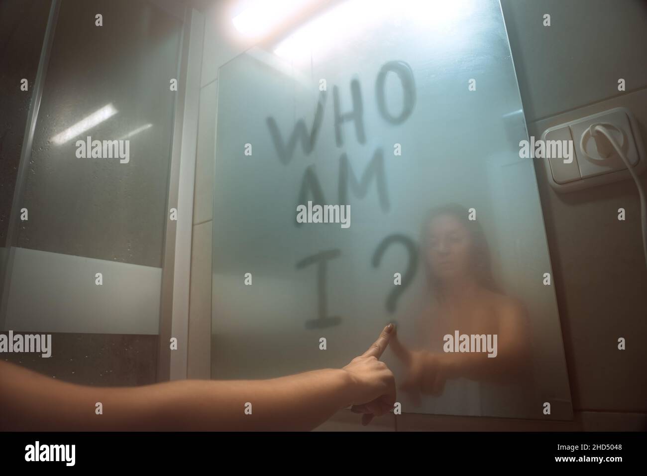 Woman writing on the mirror who am I. self awareness, identity or personality concept Stock Photo