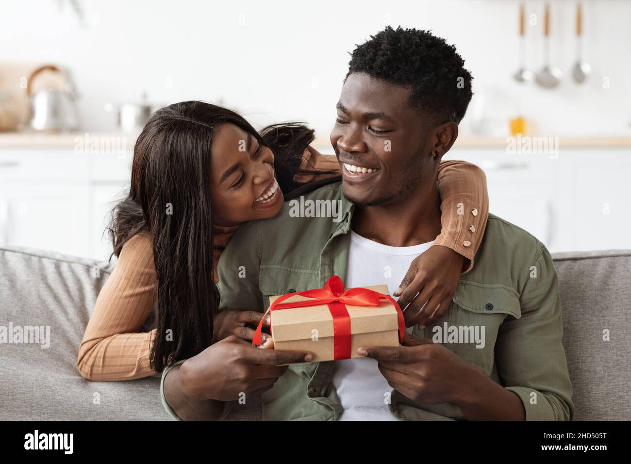 Emotional african american woman hugging her lover, giving present ...