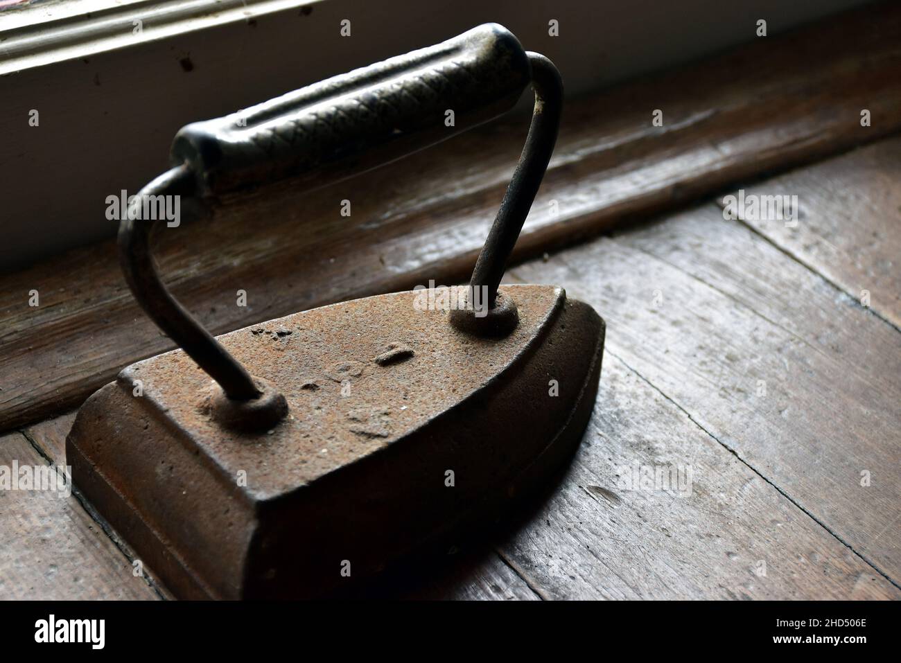 Rusted Old Iron by Wood Windowsill and Sitting on Brown Wood Slats Stock Photo