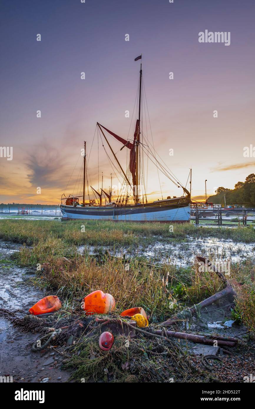 Thames sailing barges lie on the mud at Pin Mill as the day breaks. Stock Photo