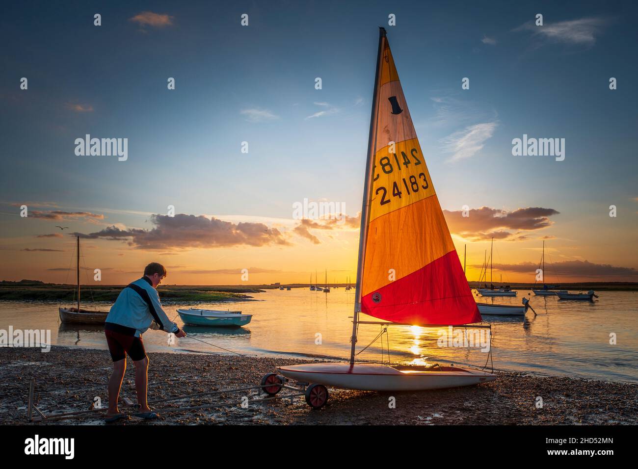 Teenage boy retrieving a dinghy after an evening sail. Stock Photo