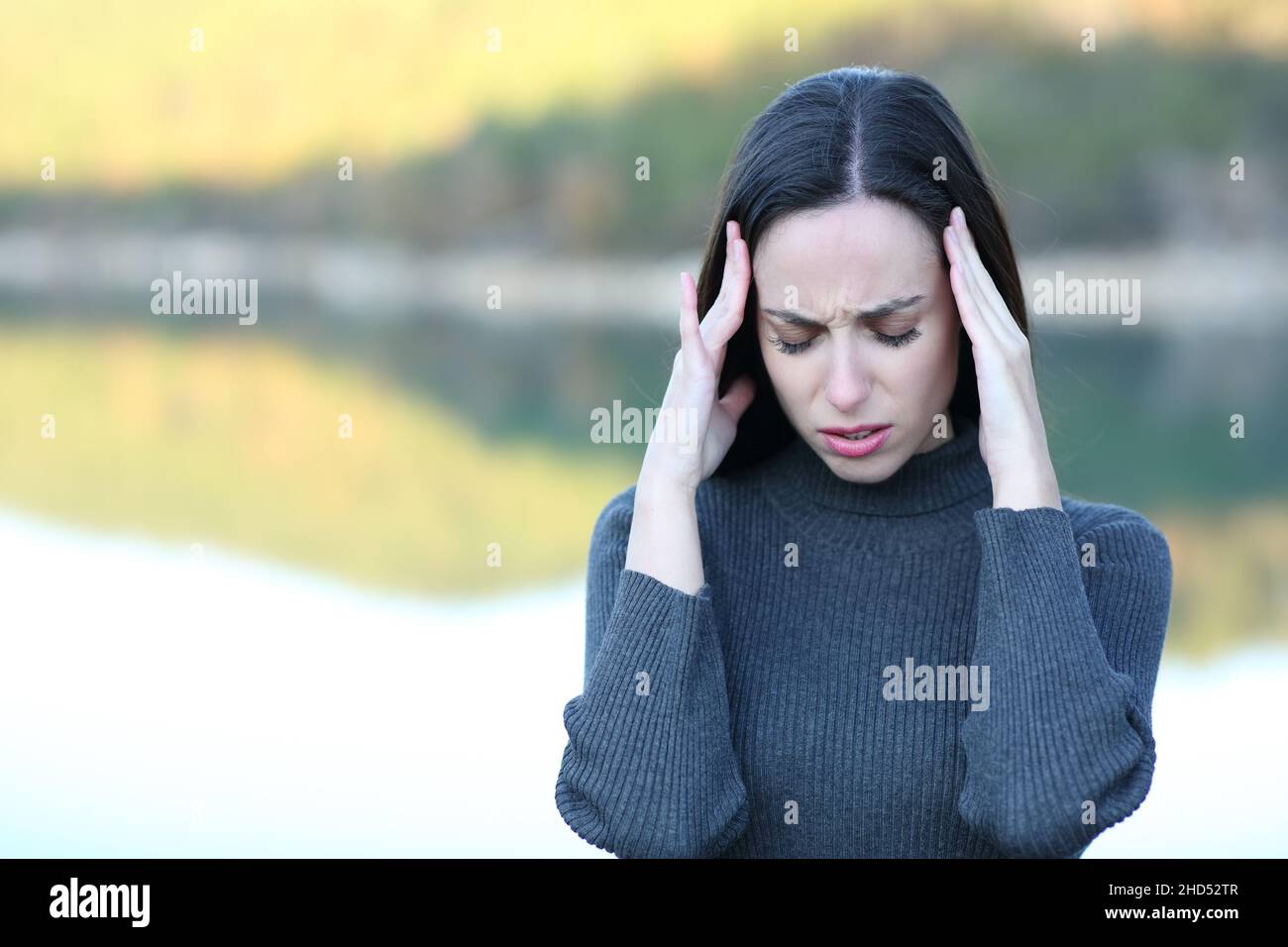 Front view portrait of a woman suffering migraine in a lake Stock Photo