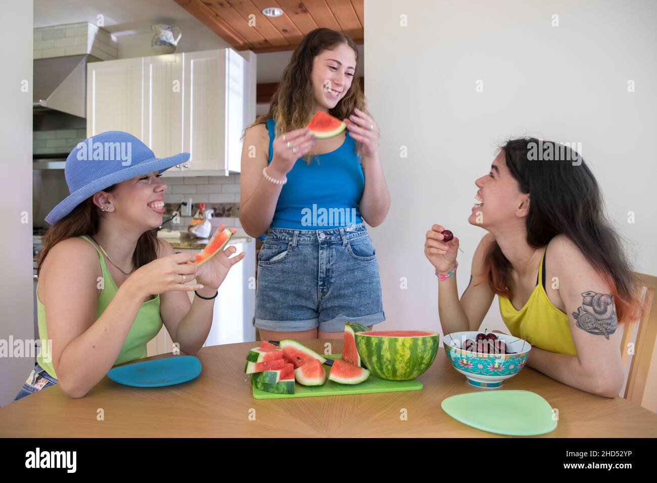 Three Female College Friends eat watermelon and cherries Stock Photo
