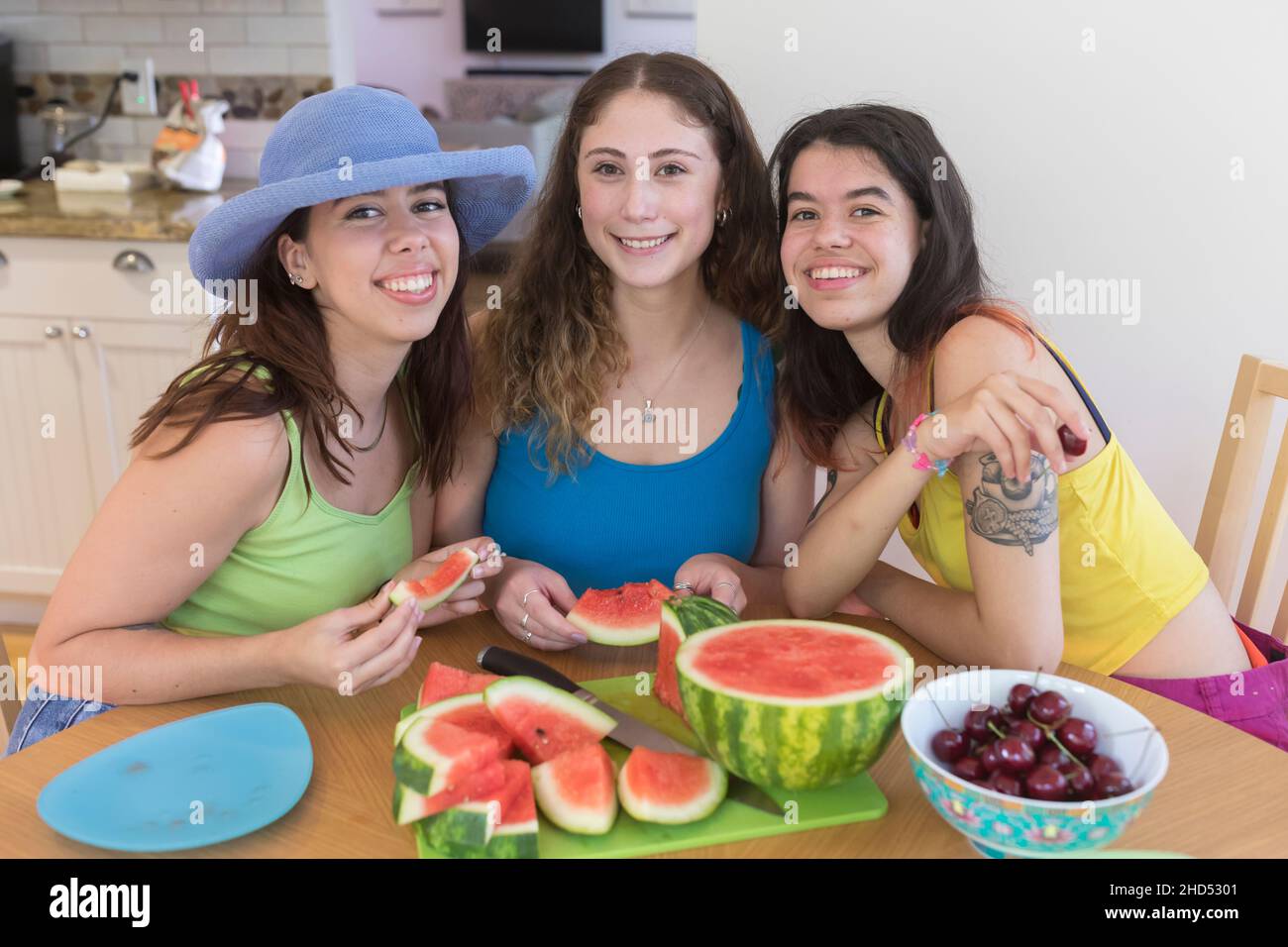 Three Female College Friends pose for a photo with summer fruit Stock Photo