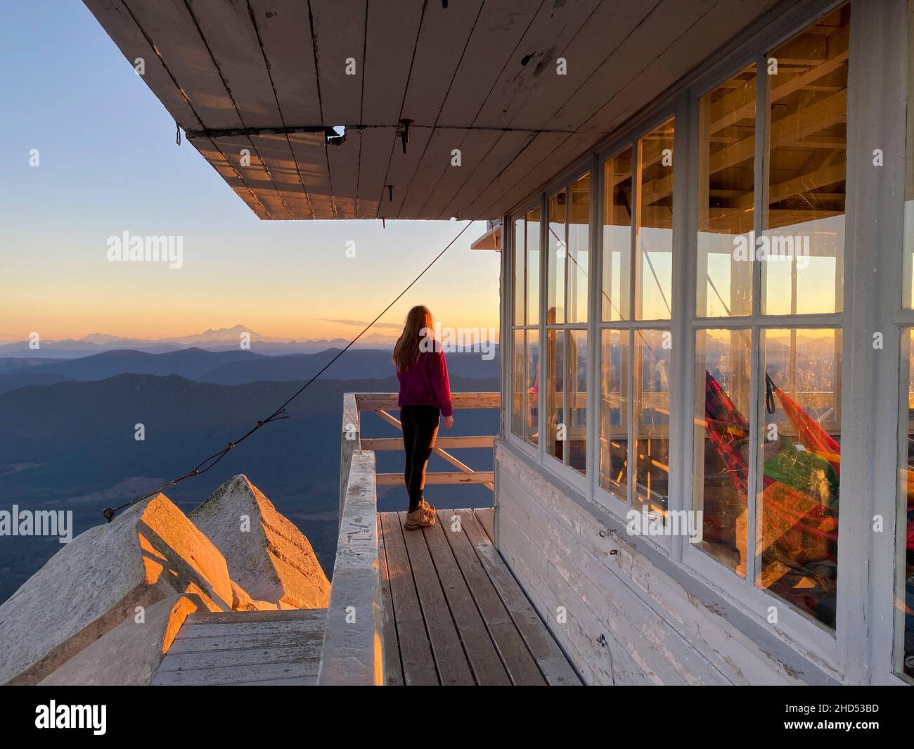 Girl watching sunrise at Mount Pilchuck in the North Cascades Stock Photo
