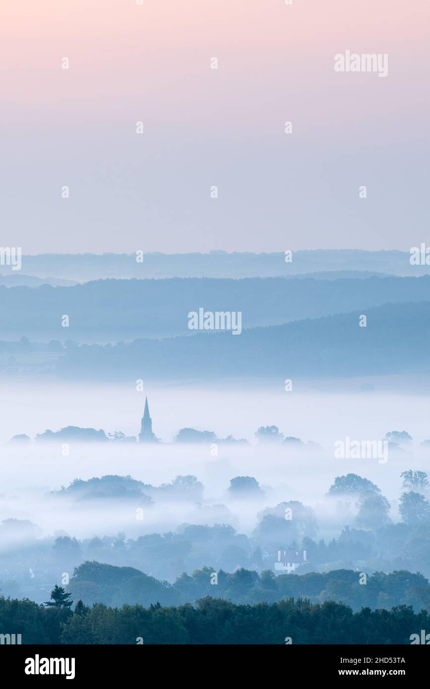 The steeple of St Barnabas Church in Weeton rises above the mists drifting over Arthington Pastures on a cool early autumn morning before sunrise. Stock Photo