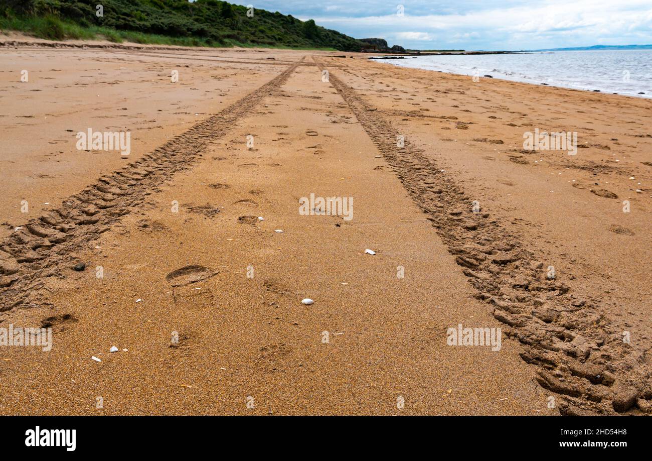Tyre tracks leading into the distance on a deserted empty beach, Gullane, East Lothian, Scotland, UK Stock Photo