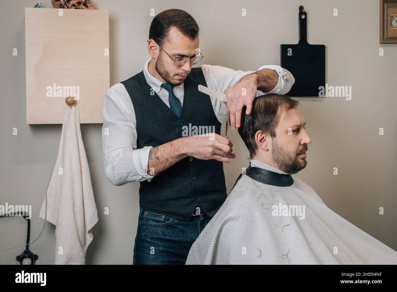 Hairdresser cuts hair on his head with scissors. Stock Photo