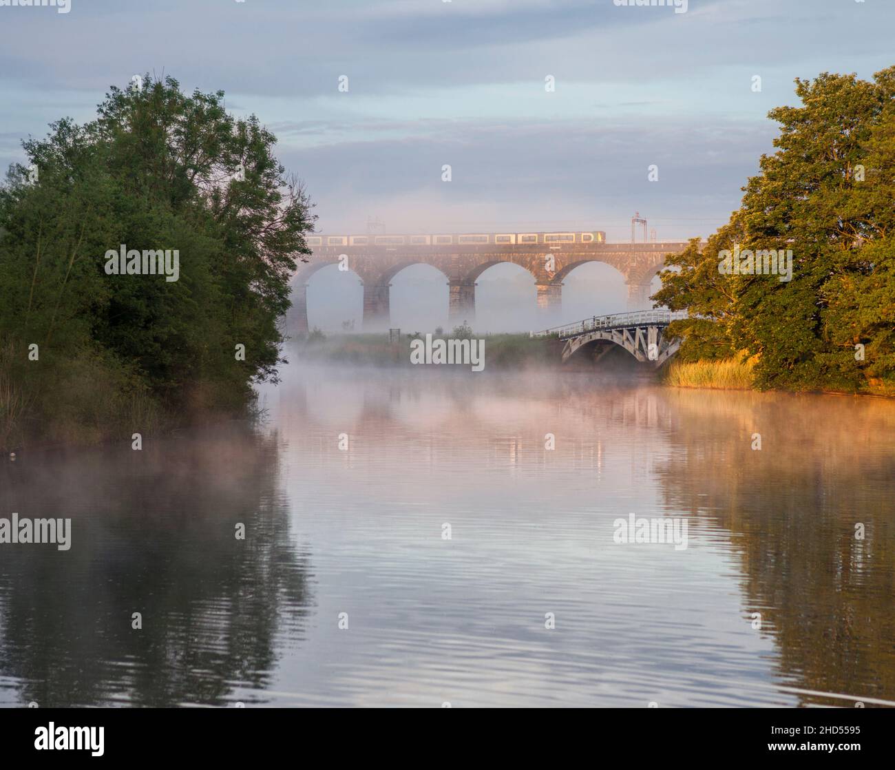 London North western railway class 350 electric train crossing Dutton viaduct  over the Weaver navigation, Cheshire on a misty morning Stock Photo