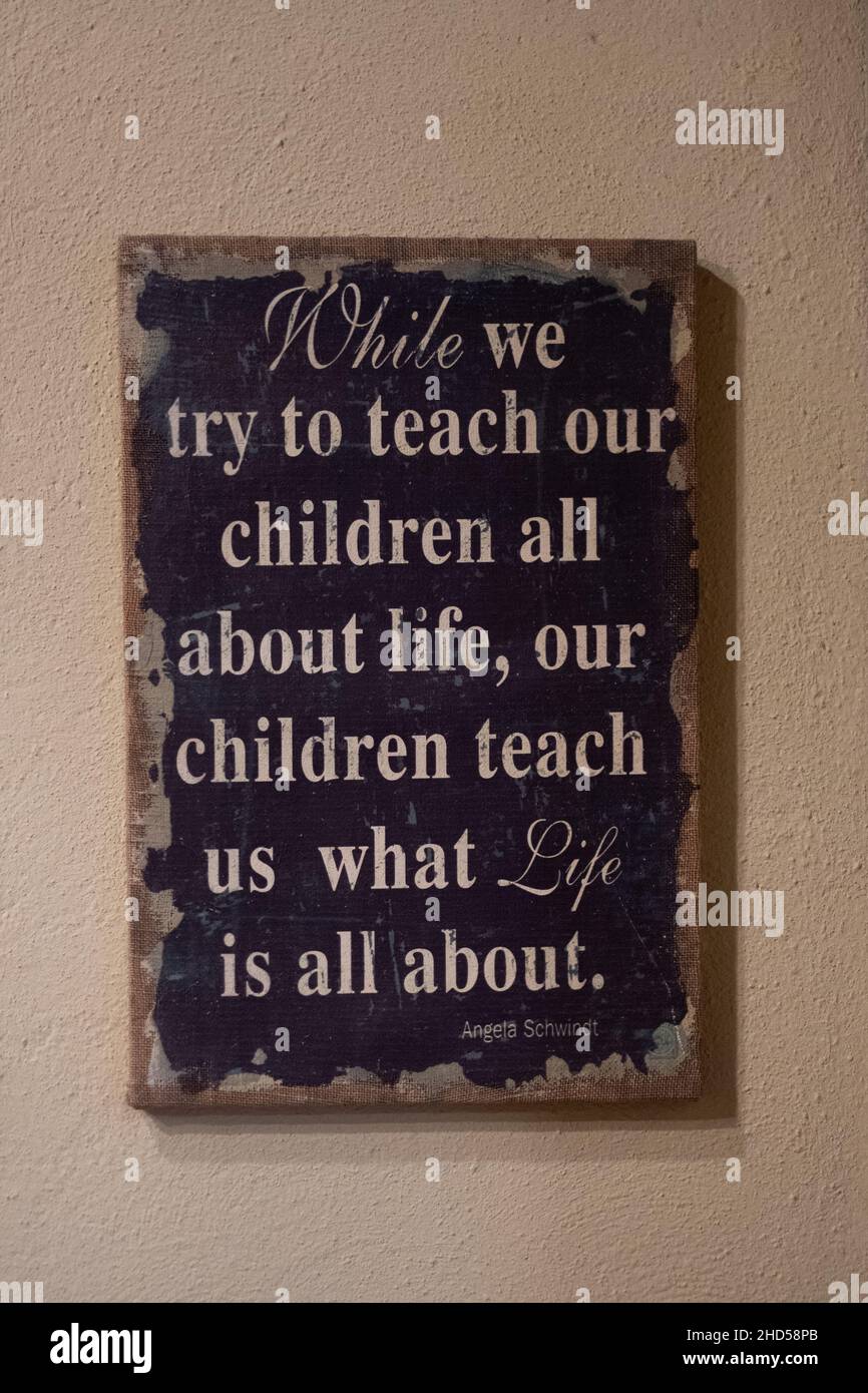 Sign on a wall saying 'While we try to teach our children all about life, our children teach us what life is all about. Lessons of life. Quote Stock Photo