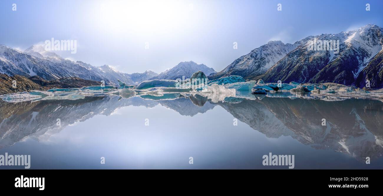 Beautiful view of the mountains and hills reflected on the lake with a shining sun Stock Photo