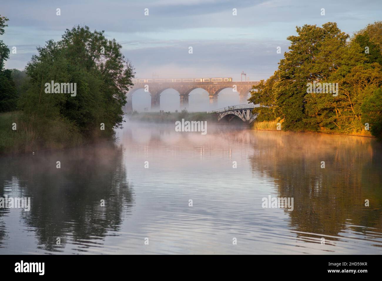 London North western railway class 350 electric train crossing Dutton viaduct  over the Weaver navigation, Cheshire on a misty morning Stock Photo