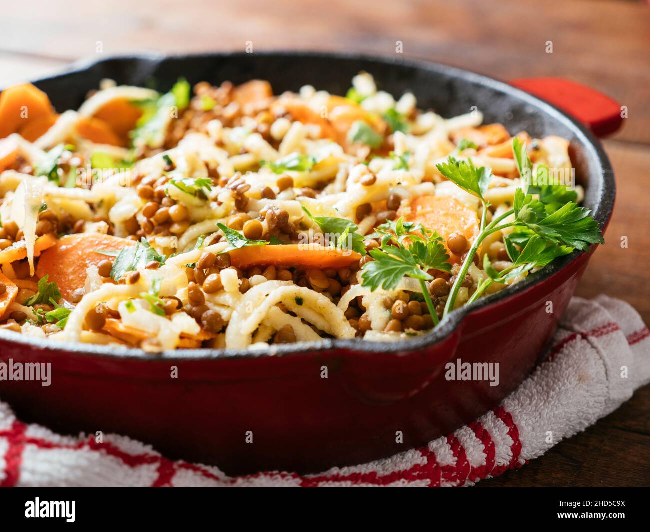 Carrots and Lentils with German Pasta (Spaetzle) in a cast iron pan Stock Photo