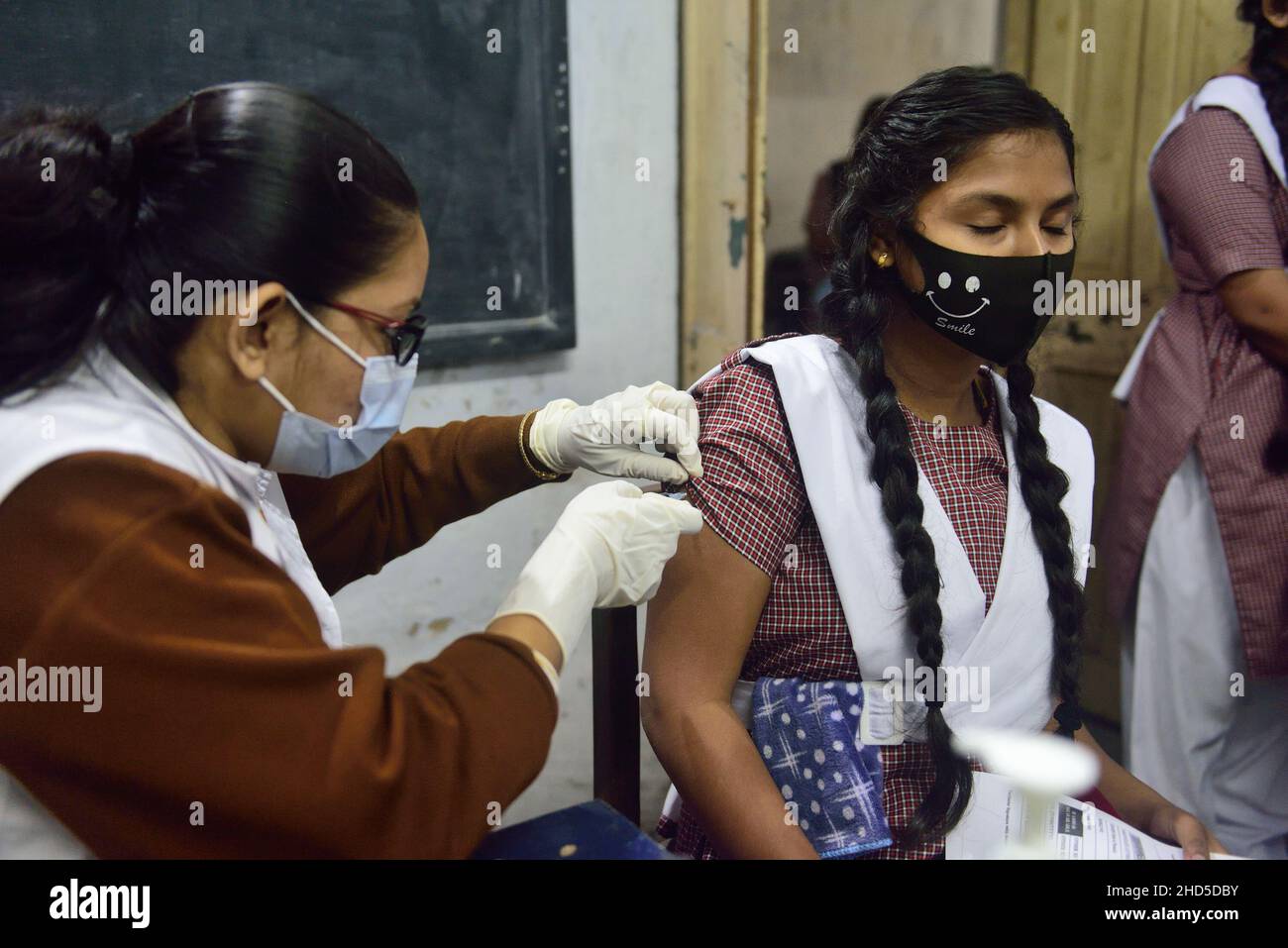 Kolkata, India. 1st Jan, 2014. A health worker administers a dose of Covaxin vaccine to a student at Uccha Balika Vidyalaya (Barisha) school in Kolkata.In India Covid vaccination for 15 to 18 year age group starts today. Nearly 2.7 million teenagers have registered for their jabs even as a country witnessing a sharp surge of Covid-19 cases fueled by the new Omicron variant of coronavirus. (Credit Image: © Sumit Sanyal/SOPA Images via ZUMA Press Wire) Stock Photo