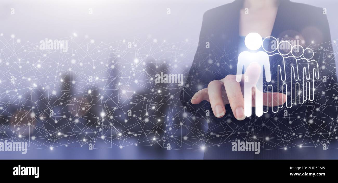 Business communication concept. Marketing. Teamwork. Hand touch digital screen hologram Human, Leader sign on city light blurred background. Recruitme Stock Photo