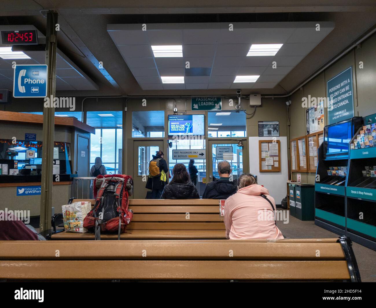 Anacortes, WA USA - circa November 2021: View of people sitting and standing, waiting for the arrival of a Washington State Ferry in the lobby. Stock Photo