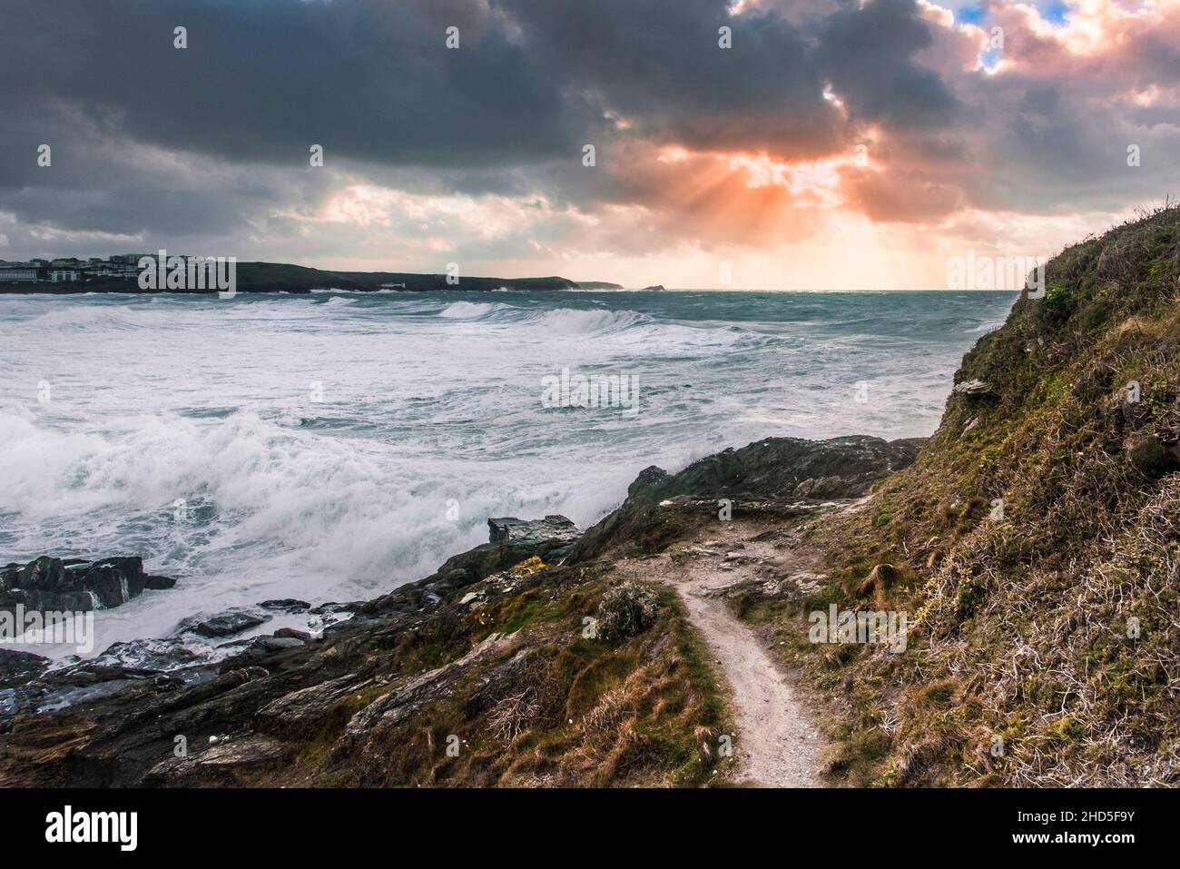 Sunset over Fistral Bay seen from the coast path on Towan Head in Newquay in Cornwall. Stock Photo