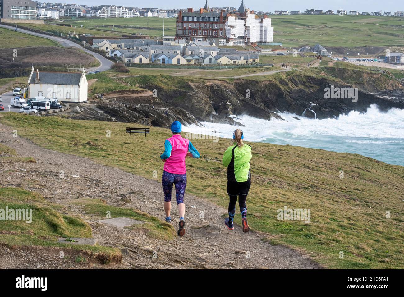 Two female friends running down a rough footpath on Towan Head in Newquay as part of their keep fit regime. Stock Photo