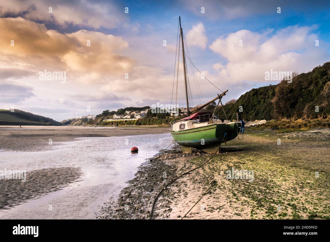 A boat beached on the foreshore of Gannel River at low tide in Newquay in Cornwall. Stock Photo