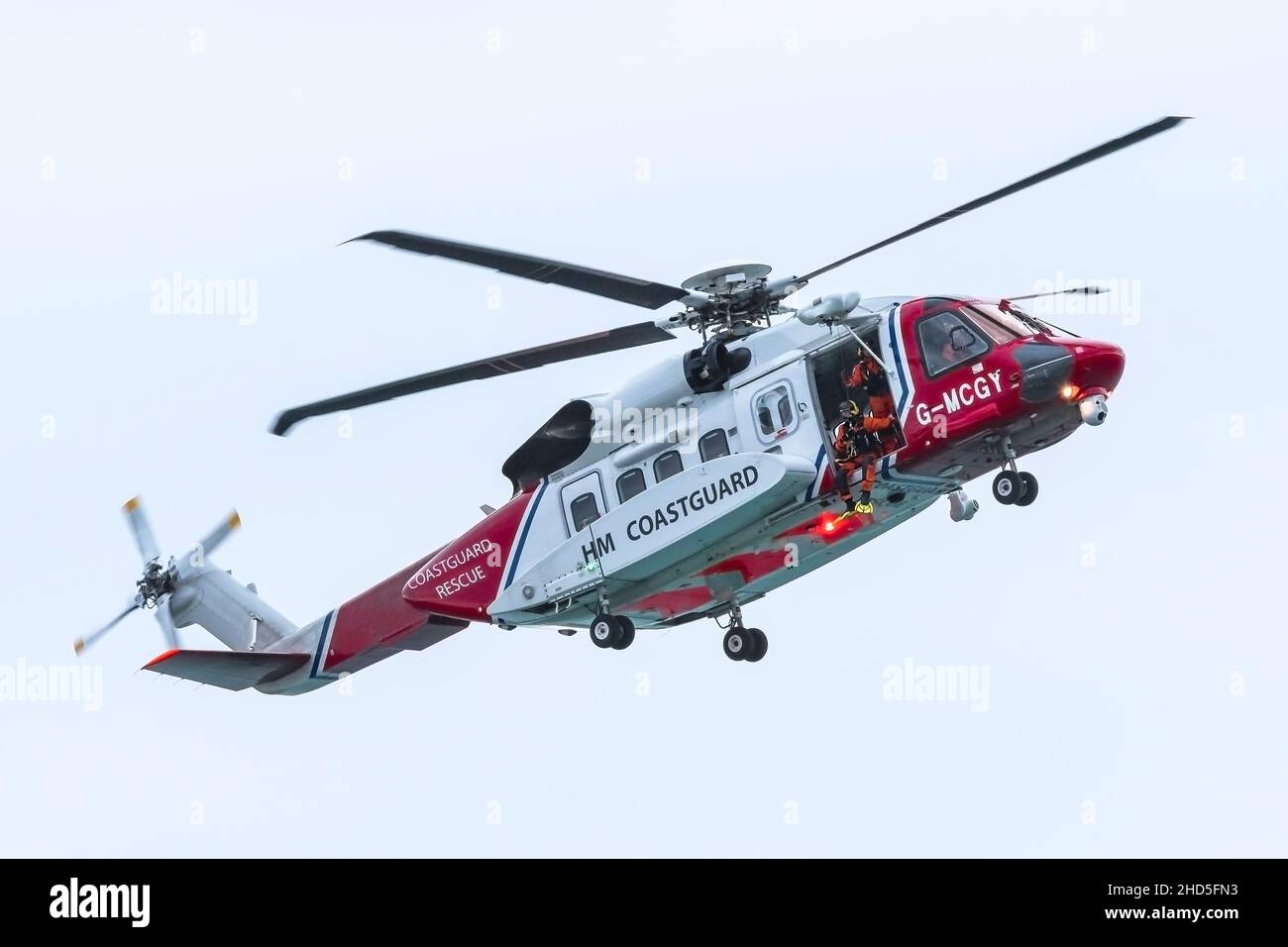 Sikorsky S-92A G-MCGY HM Coastguard Helicopter based at Cornwall Airport Newquay flying overhead on an emergency callout at Fistral in Newquay in Cornwall. Stock Photo