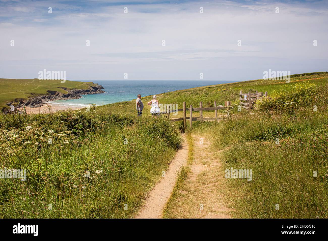 A footpath leading through fields to a wooden gate and leading down to Polly Porth Joke in Newquay in Cornwall. Stock Photo