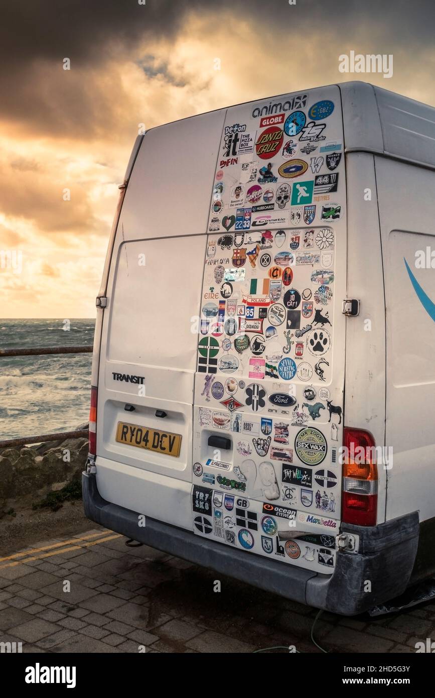 Various colourful stickers decorating the rear door of a camper van parked at Little Fistral in Newquay in Cornwall. Stock Photo