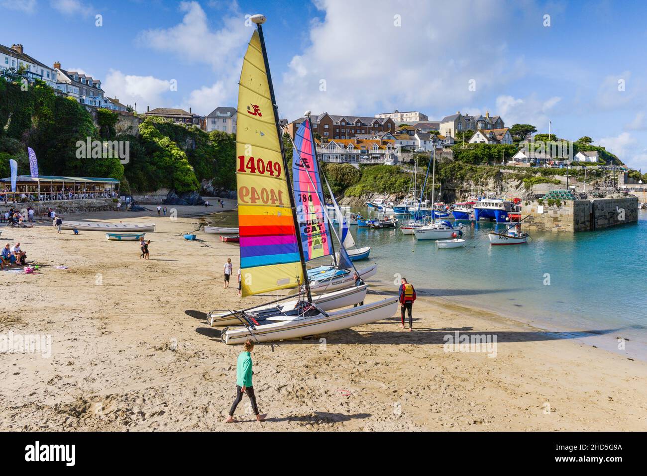 Hobie Cat Catamarans with colourful sails beached in the historic picturesque working Newquay Harbour in Newquay on the North Cornwall coast. Stock Photo