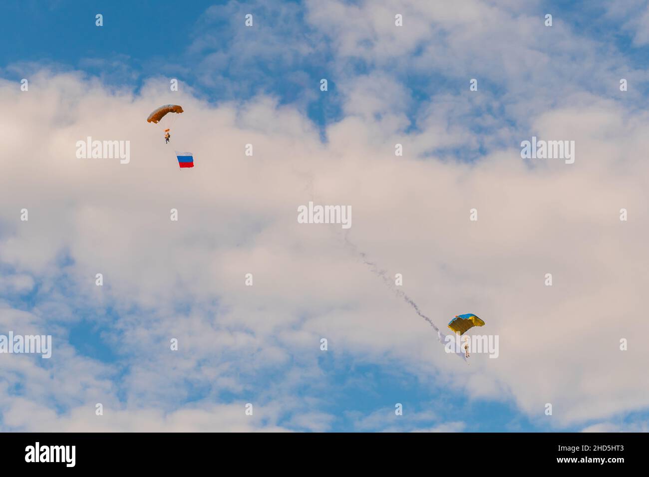 Two skydivers flying with parachute against blue sky - extreme sport concept Stock Photo