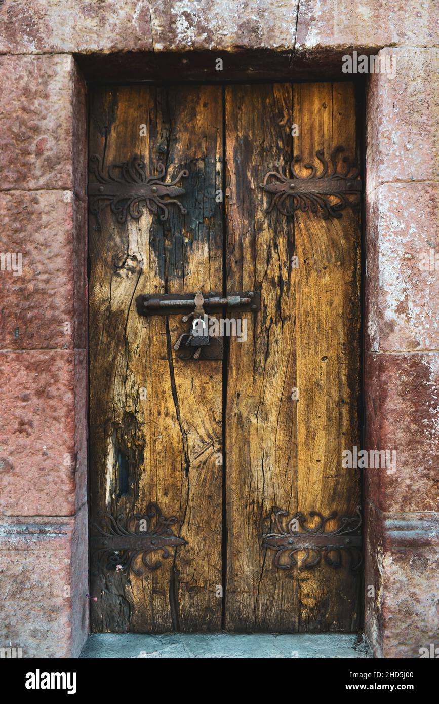 Hand forged iron door hinges for antique wooden doors with decorative locks in San Miguel de Allende, Mexico Stock Photo