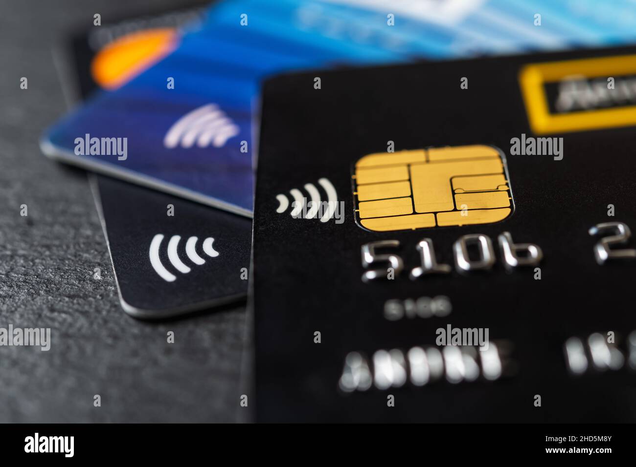 Three credit cards with contactless pay technology macro. Bank charge cards for goods and services payments. Plastic debit card for money transfers. Stock Photo