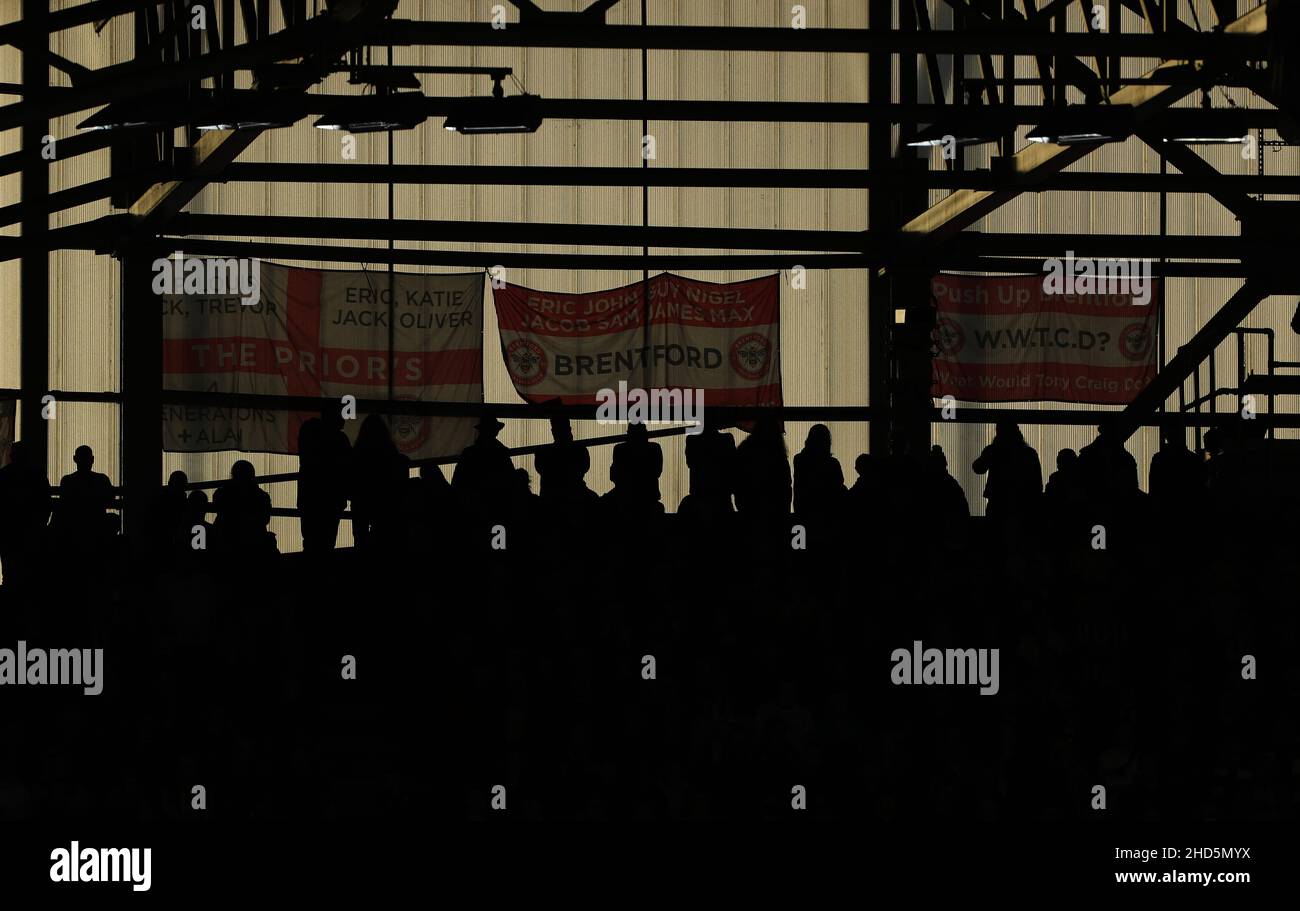 BRENTFORD, ENGLAND - JANUARY 02: A general view of silhouetted Brentford fans and flags during the Premier League match between Brentford and Aston Villa at Brentford Community Stadium on January 2, 2022 in Brentford, England. (Photo by Ben Peters/MB Media) Stock Photo