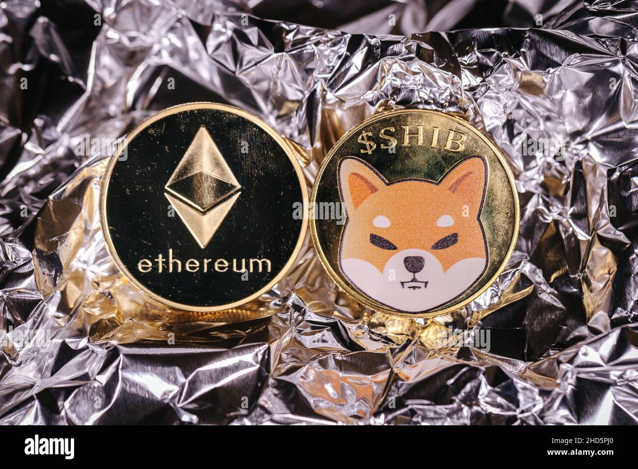 Ethereum and Shiba Inu cryptocurrency, physical coins in front of an abstract background. Stock Photo