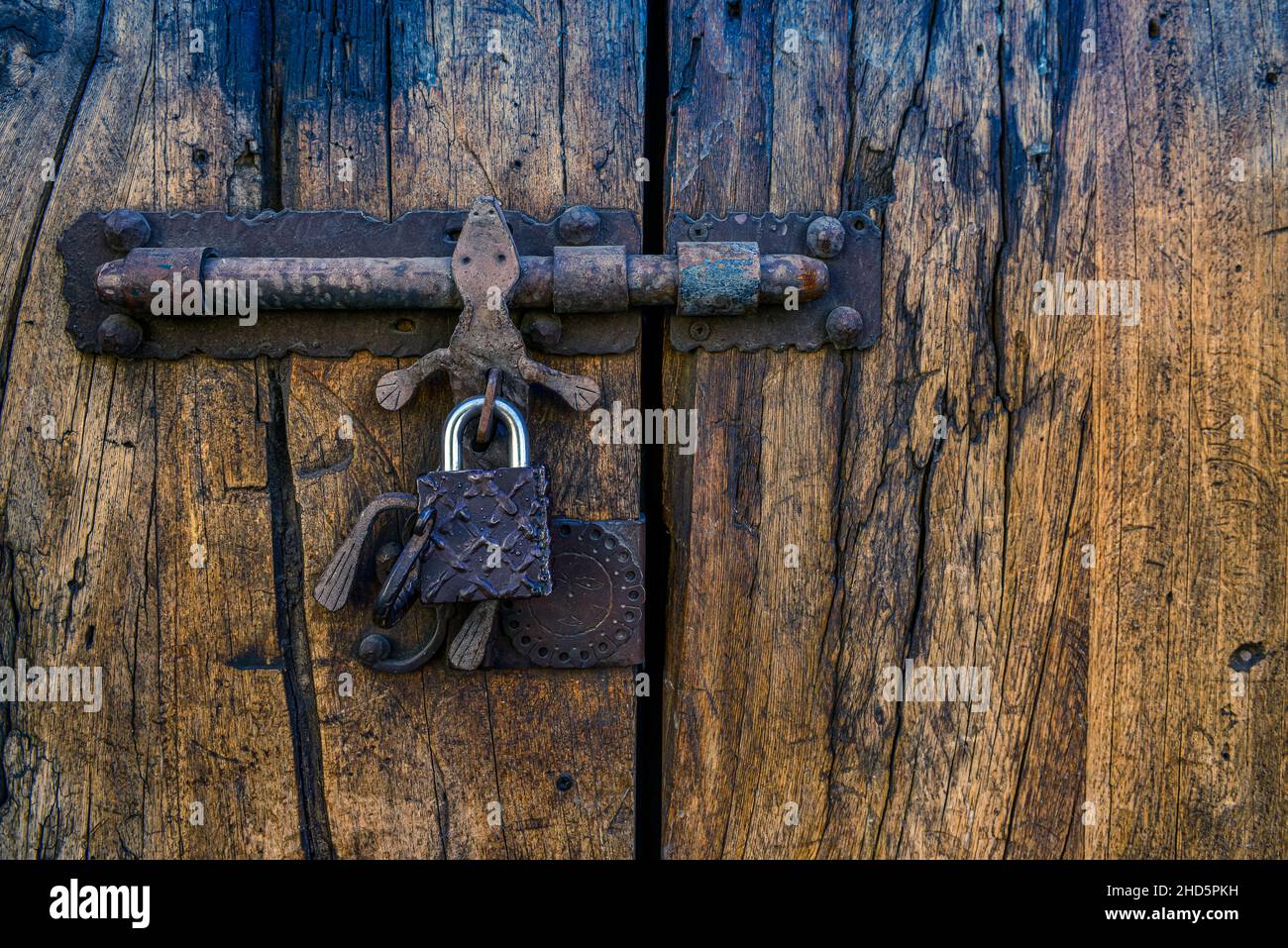 Close-up of exterior bolt latched old wooden doors with gecko art handle, ornamental hand forged metal in San Miguel de Allende, Mexico Stock Photo
