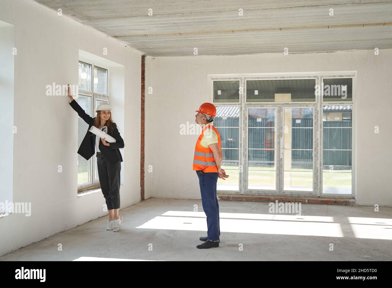 Woman explaining builder his work about the wall Stock Photo