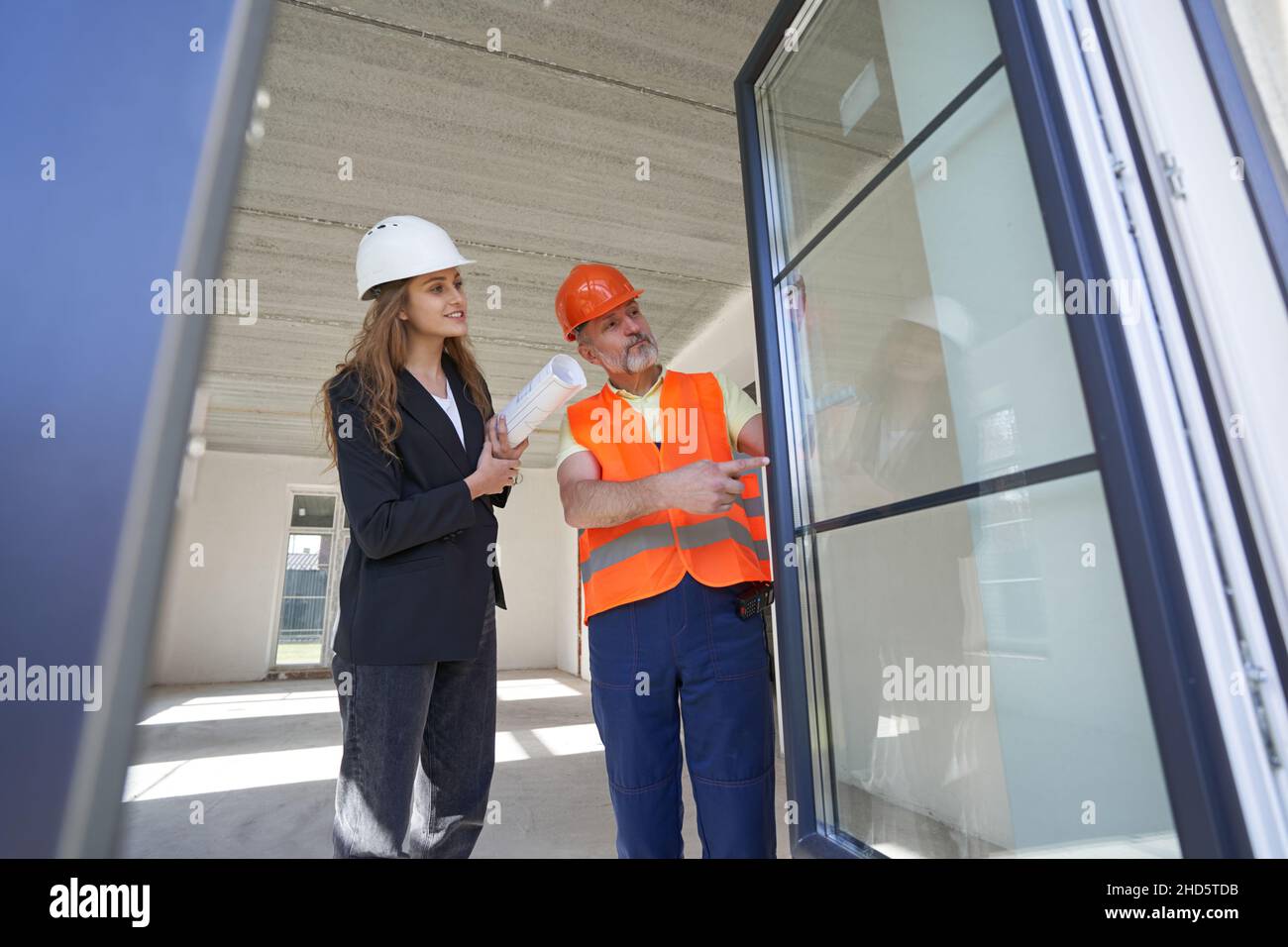 Young woman designer examining door with housebuilder Stock Photo