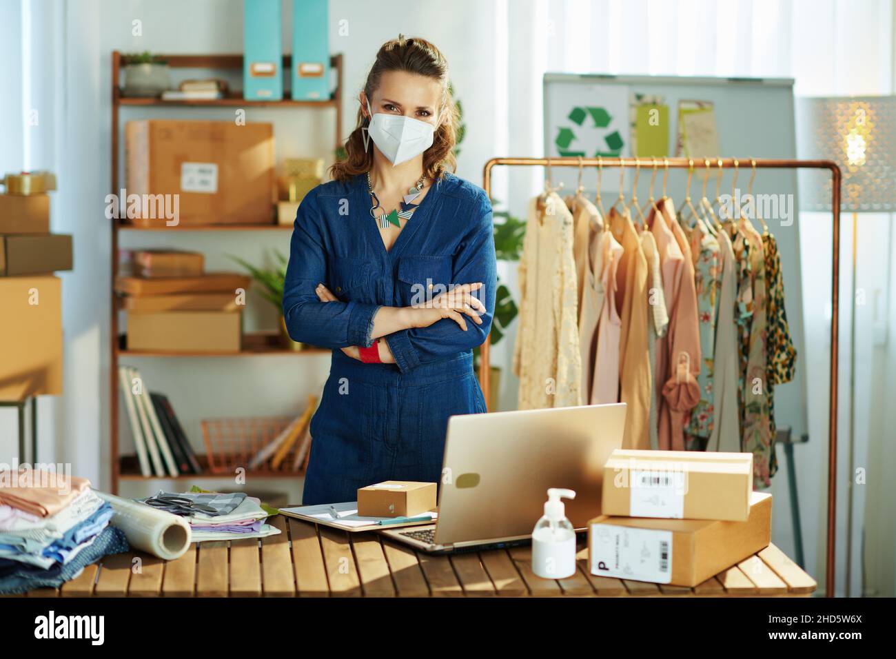modern small business owner woman with ffp2 mask and antiseptic in the office. Stock Photo